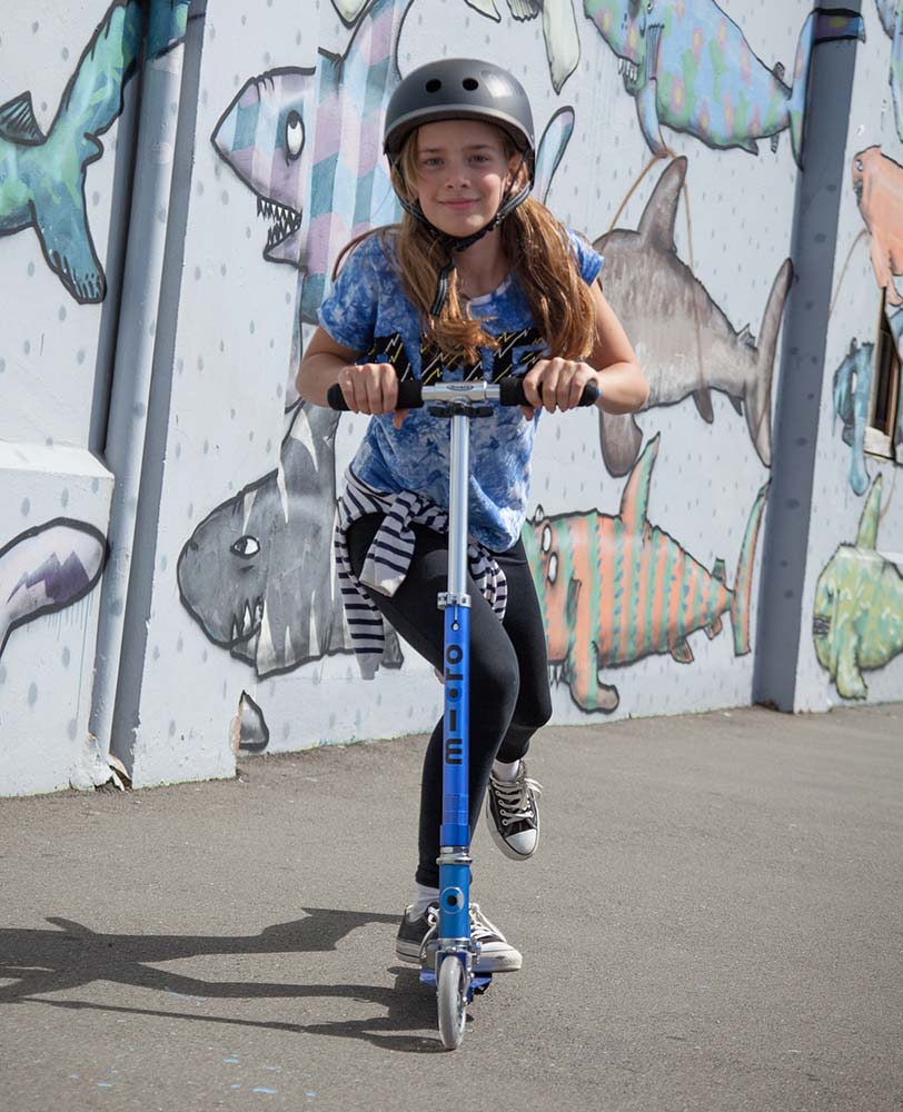 girl riding on a sapphire blue sprite kids scooter