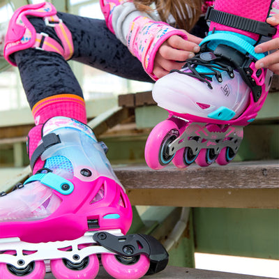 girl putting her pink inline skate on