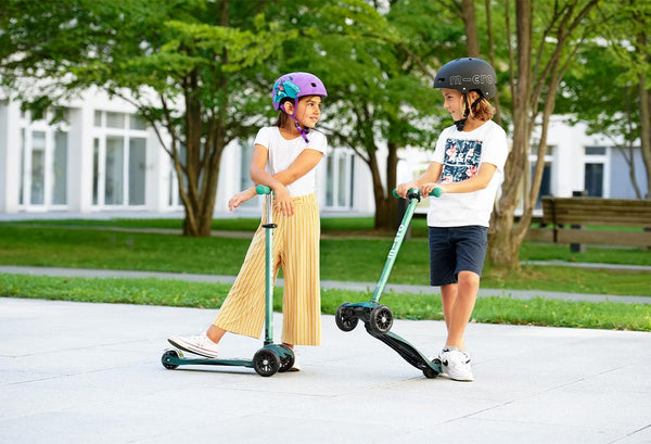 kids scooting on the Maxi Micro Deluxe Eco scooter deep green