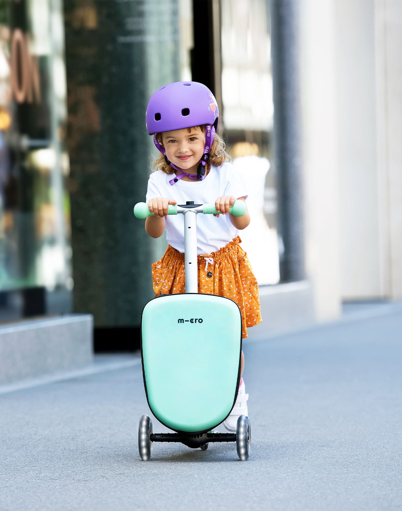 toddler riding their luggage junior scooter mint