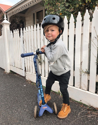 boy on his blue mini deluxe with scooter carry strap