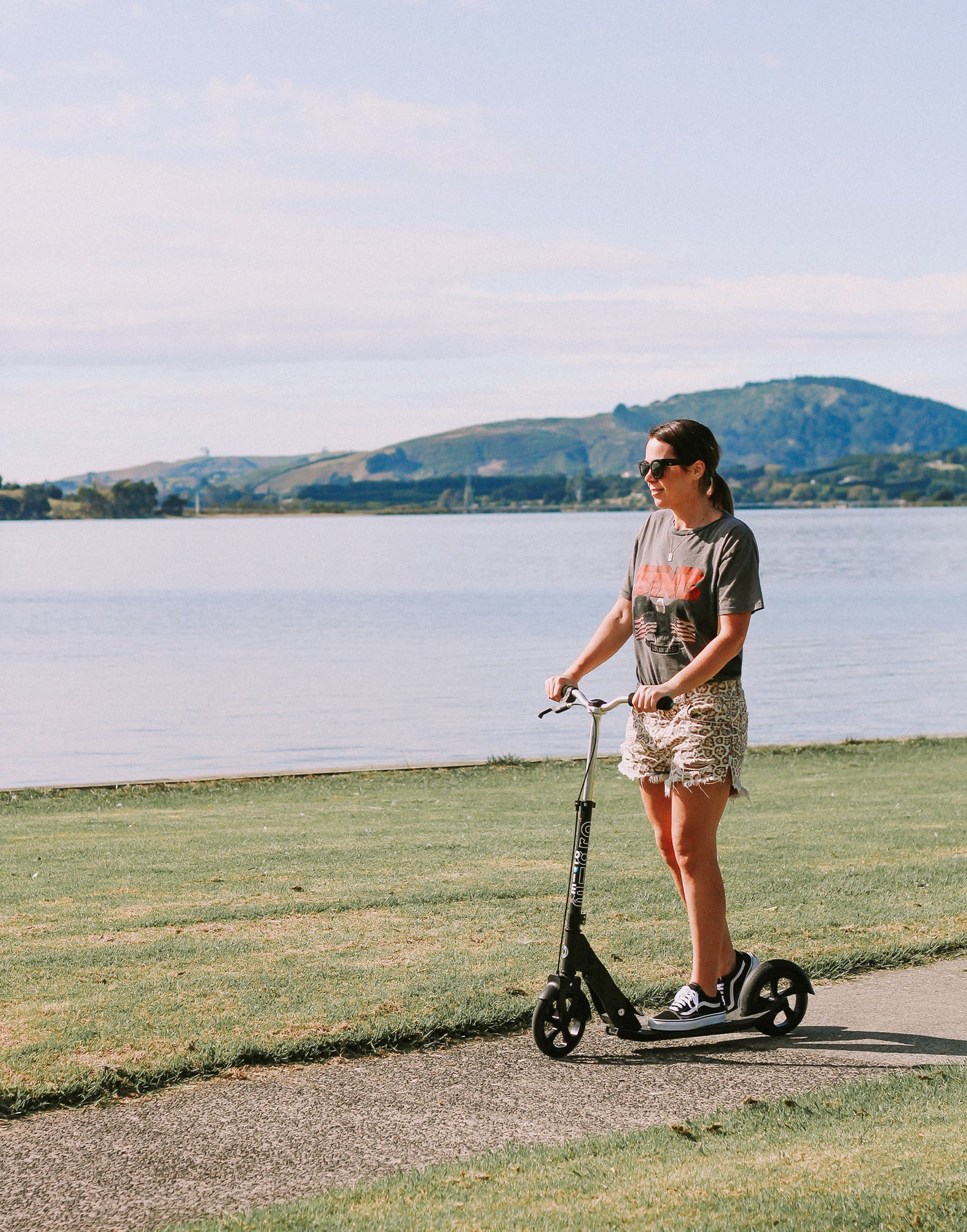 woman riding downtown adult 2 wheel scooter along the waterfront