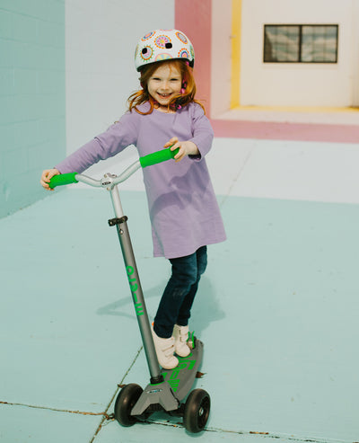 girl on a grey and green maxi deluxe pro kids scooter