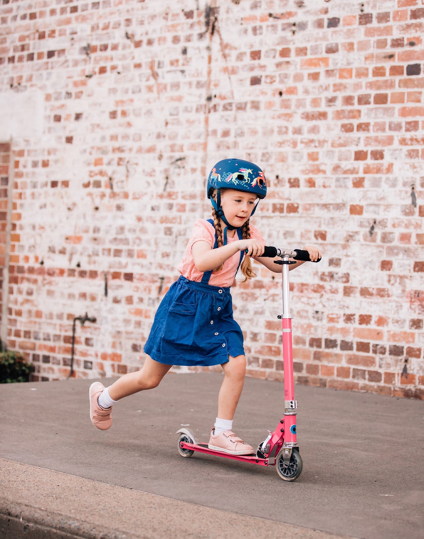 girl riding her pink kids sprite scooter