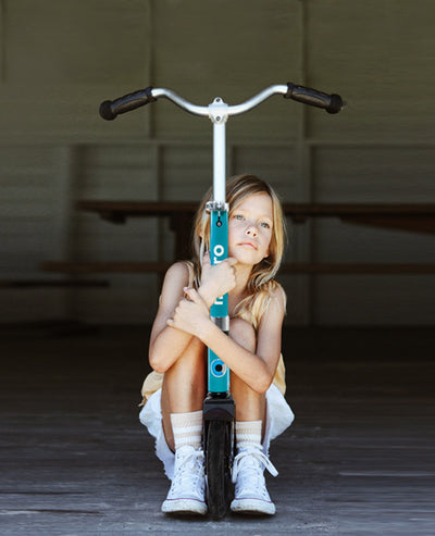 girl sitting and hugging her aqua cruiser scooter