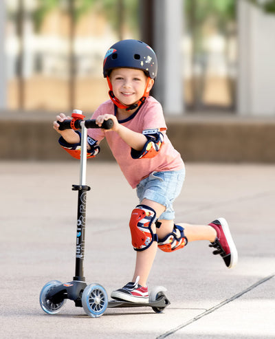 toddler riding scooter wearing rocket knee and elbow pads