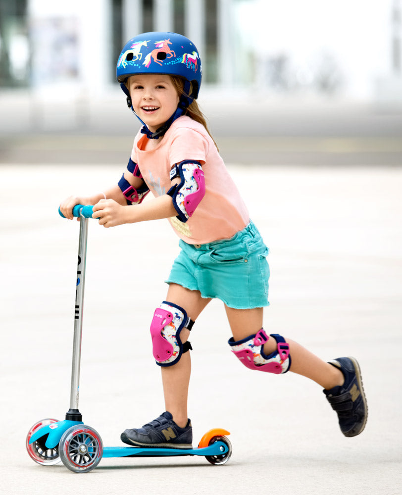 girl riding mini classic with unicorn knee and elbow pads on