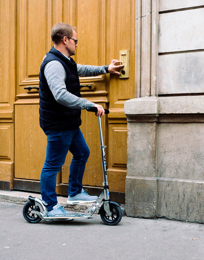 man entering his apartment building on flex air adult scooter