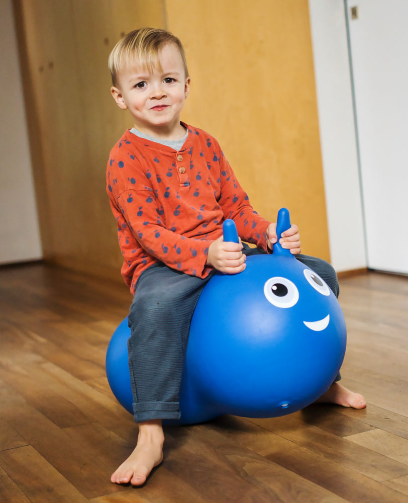 toddler on his blue inflatable air hopper with removable wheels