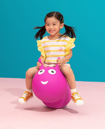 toddler jumping on their pink inflatable air hopper with removable wheels